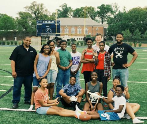 Austin Brown (far left) and Eno Umoh (far right) at their High School, Gilman, after teaching some youth and flying on the football field. Photo: FAA and Global Air Media