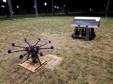 The roofing octocopter, equipped with a nail gun, is parked near the mock roof. By setting the wooden panel at different inclines, the researchers simulated roofs with different slopes. Image credit: Matthew Romano, Michigan Robotics